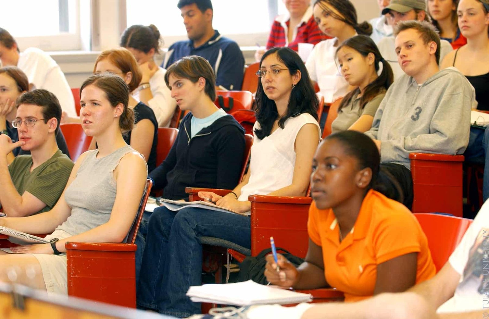 College students listening and taking notes in a lecture hall